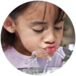 Girl drinking from a water fountain
